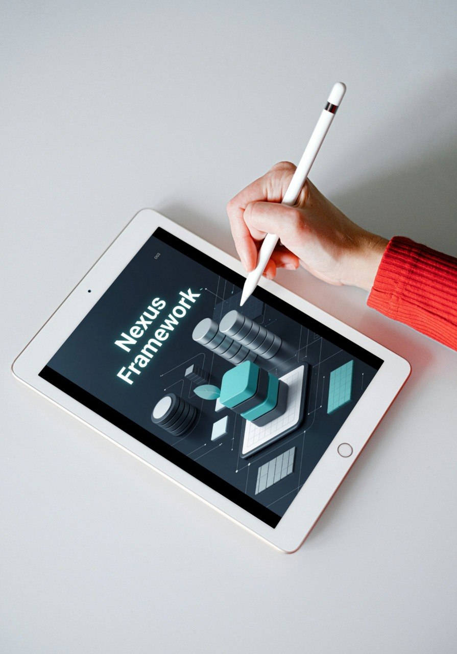 Person using a stylus on a tablet displaying 'Nexus Framework' on a light gray background